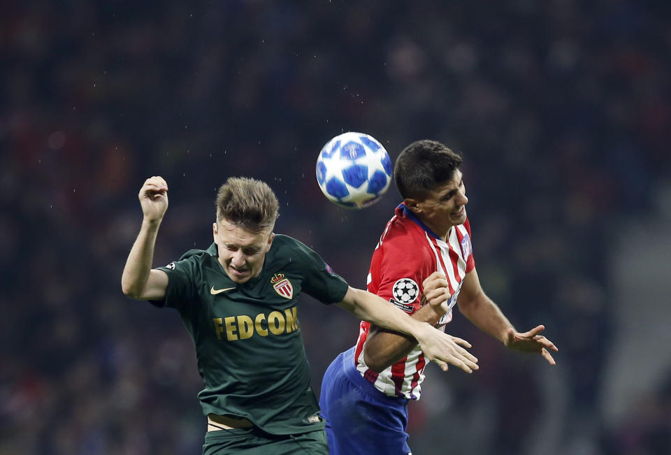 Monaco's Aleksandr Golovin, left, jumps for the ball with Atletico Madrid's Rodri during a Group A Champions League soccer match between Atletico Madrid and Monaco at the Metropolitano stadium in Madrid, Wednesday, Nov. 28, 2018. (AP Photo/Paul White)