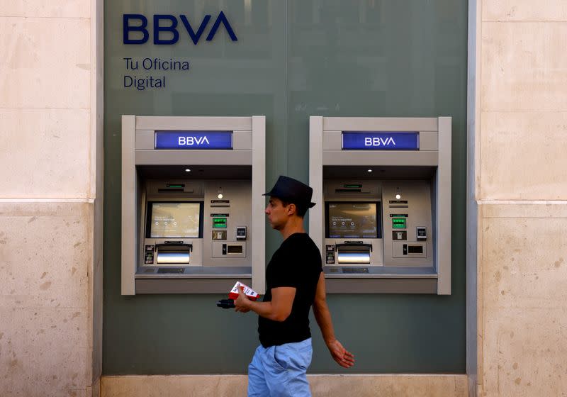 A man walks past ATM machines of a BBVA bank branch office in Malaga