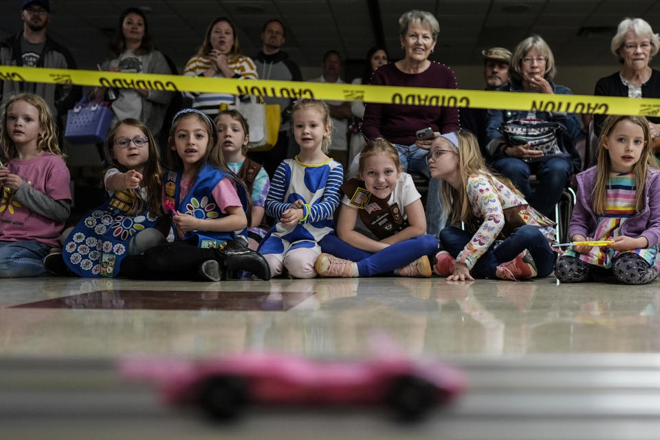 Girl Scout Daisys watch a car race during the Girl Scouts Pinewood Derby, Saturday, April 13, 2024, in Marietta, Ga. (AP Photo/Mike Stewart)