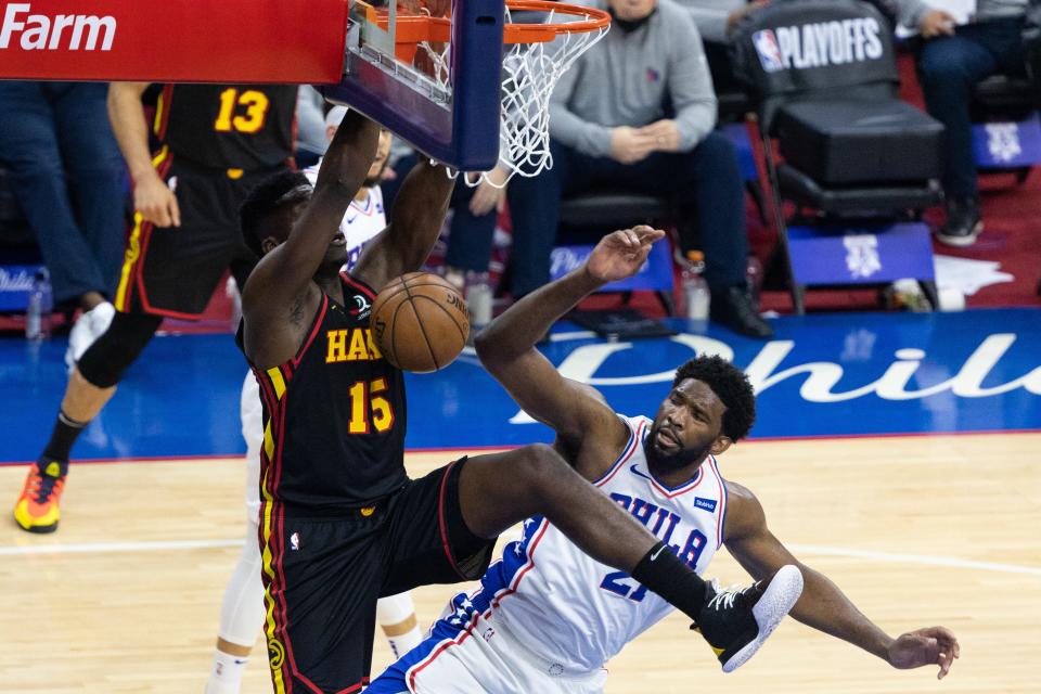 The Hawks' Clint Capela dunks the ball past the 76ers' center Joel Embiid.