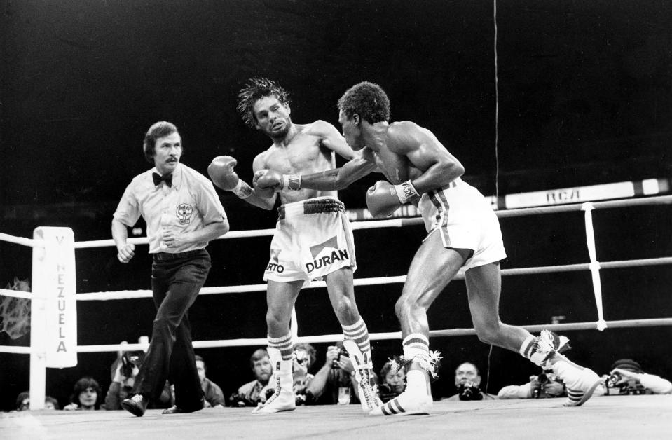 En esta foto del 20 de junio de 1980, Roberto Durán, a la izquierda, recibe un golpe de Sugar Ray Leonard durante su pelea en Montreal, Canadá, mientras el réferi Carlos Padilla, a la izquierda, los mira. Un documental sobre el ícono panameño del boxeo, "I am Duran", se estrenará el 4 de junio del 2019 en múltiples plataformas digitales. (AP Foto, Archivo)