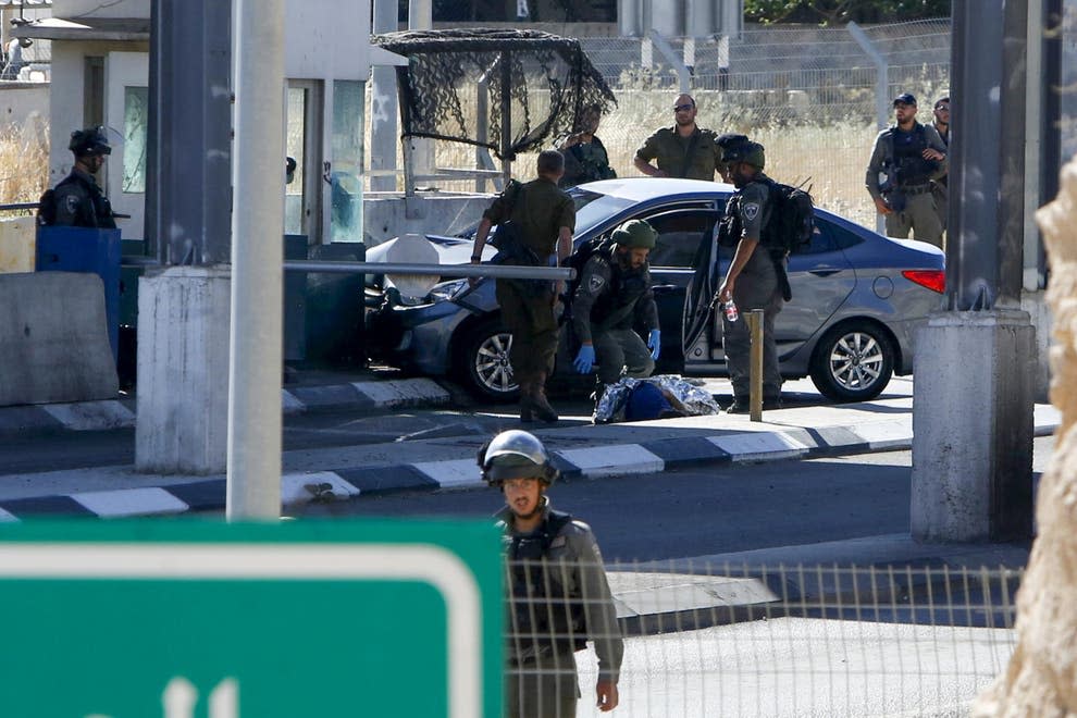 <p>Israeli forces cover the body of Ahmed Erekat</p> (AFP/Getty)