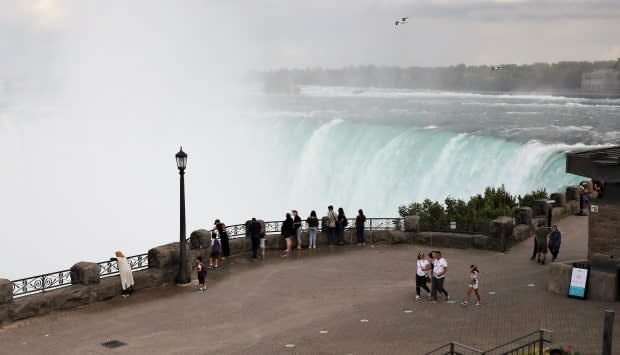 A handful of people are seen on the normally jammed walkway in Niagara Falls, Ont., on Monday, July 13, 2020. Anti-COVID measures, particularly the closure of the U.S. border, prompted a steep decline in visitors to one of the world's top tourist destinations.  (Colin Perkel/CP - image credit)