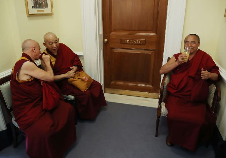 Buddhist Monks wait in the hallway while the Dalai Lama attends a meeting at the US Capitol on June 14, 2016