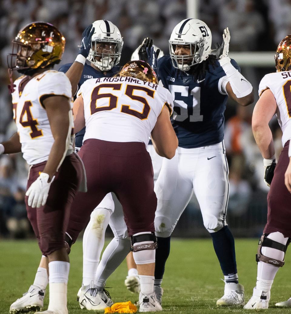 Penn State's Hakeem Beamon (51) and Dani Dennis-Sutton hold their hands up to their ears after the deafening noise from the fans caused a false start for the Minnesota offense at Beaver Stadium on Saturday, Oct. 22, 2022, in State College.