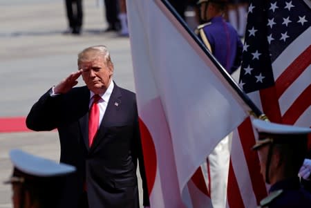 U.S. President Donald J. Trump salutes to national flags of the United States and Japan as he reviews the guard of honor during a welcoming ceremony at the Imperial Palace in Tokyo