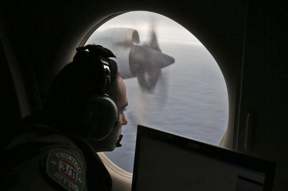 FILE - In this Saturday, March 22, 2014 file photo, Flight officer Rayan Gharazeddine on board a Royal Australian Air Force AP-3C Orion, searches for the missing Malaysia Airlines Flight MH370 in southern Indian Ocean, Australia. From “All right, good night” to “Good night, Malaysian three-seven-zero." Malaysia’s tweak to the final words received from the cockpit of the missing jetliner would appear insignificant to the investigation or hunt for the plane. (AP Photo/Rob Griffith, Pool)