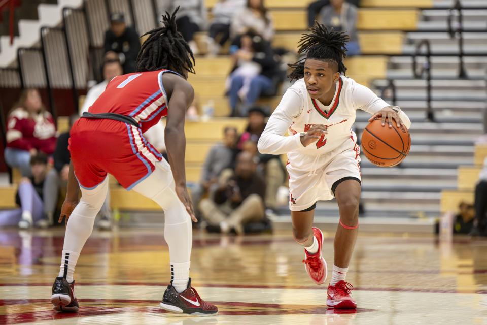 Lawrence North High School sophomore Cameron Webster (2) brings the ball up court into the defense of Fort Wayne Wayne High School senior Jevon Lewis (1) during the first half of a game in the Forum Tipoff Classic, Saturday, Dec. 9, 2023, at Southport High School.