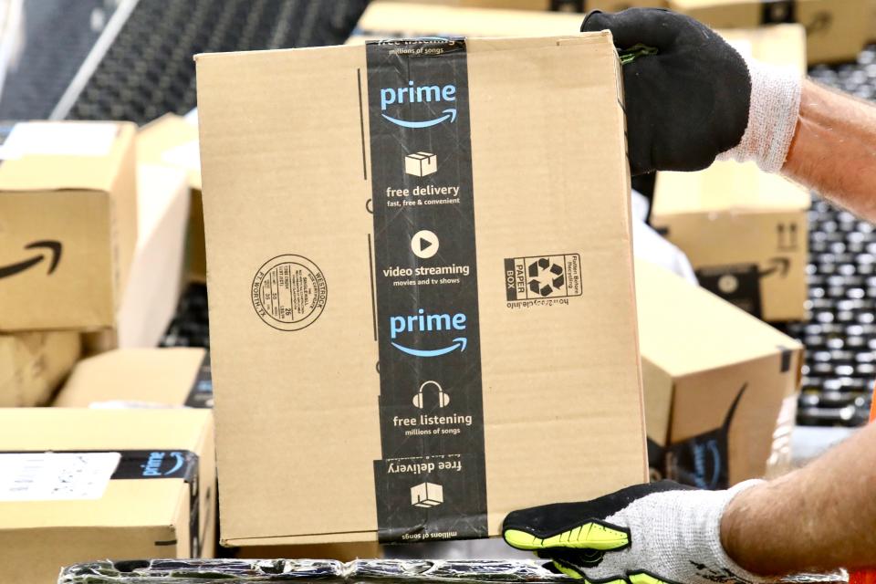 Amazon employees handle packages on Prime Day, July 11, 2023, at the Amazon Air Hub facility in Rockford