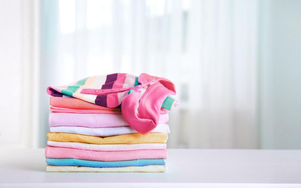 Stack of cotton colorful clothing,stacked clothes,kid's apparel.Cotton laundry. - Yana Bardichevska / Alamy Stock Photo