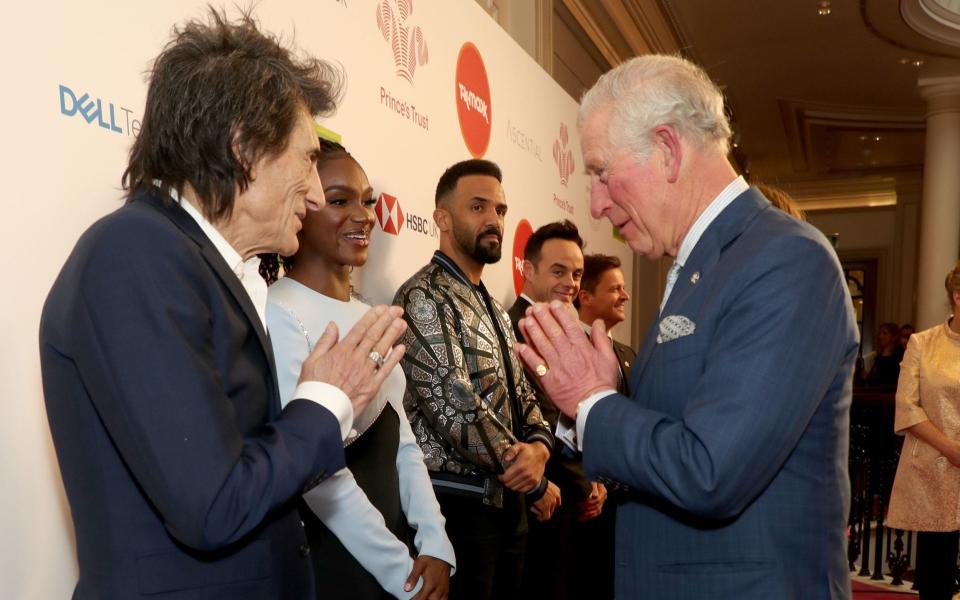 Prince Charles, Prince of Wales uses a Namaste gesture to greet Rolling Stone Ronnie Wood as he attends the Prince's Trust And TK Maxx & Homesense Awards at London Palladium on March 11, 2020 in London, England - Debrett's set to update etiquette guidelines to include no handshakes and shorter picnics - GETTY IMAGES