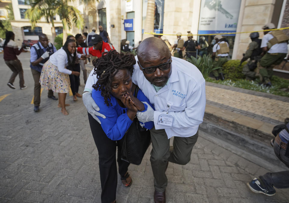 Civilians flee the scene at a hotel complex in Nairobi, Kenya Tuesday, Jan. 15, 2019. Terrorists attacked an upscale hotel complex in Kenya's capital Tuesday, sending people fleeing in panic as explosions and heavy gunfire reverberated through the neighborhood. (AP Photo/Ben Curtis)