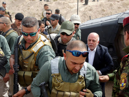 Iraq's Prime Minister Haidar al-Abadi (R) visits camp Habbaniyah in the eastern city of Ramadi April 8, 2015. REUTERS/Stringer/File Photo