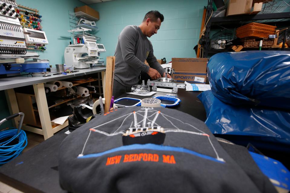 Carlos Chamorro, co-owner, checks the custom embroidery orders being prepared for individuals and businesses through the country at the recently opened Ocean Drive Screenprinting on MacArthur Drive in New Bedford.