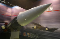 FILE - In this Aug. 10, 2011, file photo, Taiwan's indigenous Hsiung Feng III missile is propped against the backdrop of a billboard depicting a missile-riddled aircraft carrier, closely resembling China's carrier "Varyag," during a media preview of the Taipei Aerospace and Defense Technology show in Taipei, Taiwan. Chinese characters read: "Aircraft Carrier Killer." (AP Photo/Wally Santana, File)