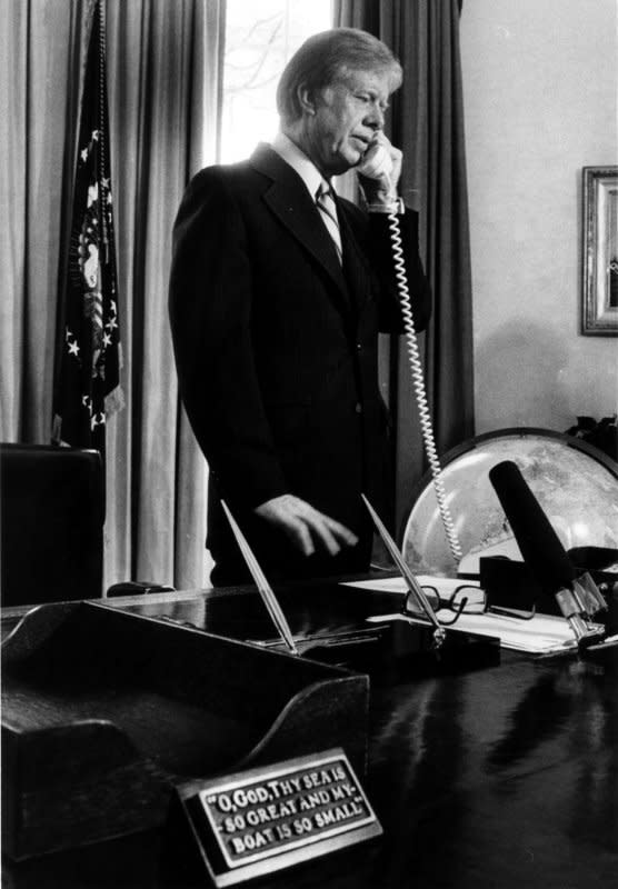 President Jimmy Carter receives a telephone call on March 28, 1980, in the Oval Office. On January 23, 1980, Carter reinstated the Selective Service System. UPI File Photo