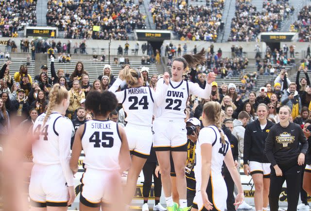 <p>Matthew Holst/Getty </p> Caitlin Clark (22) led the Hawkeyes to victory during their record-breaking preseason game on Oct. 15.