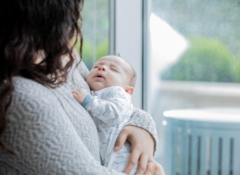 A woman holds a newborn baby