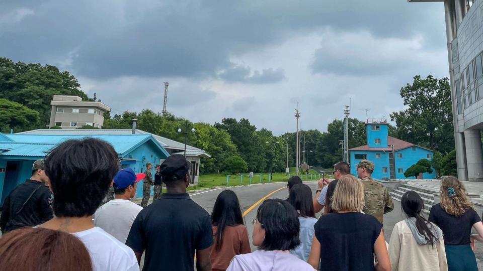 PHOTO: A group of tourists stand near a border station at Panmunjom in the Demilitarized Zone in Paju, South Korea, July 18, 2023. (Sarah Jane Leslie/AP)