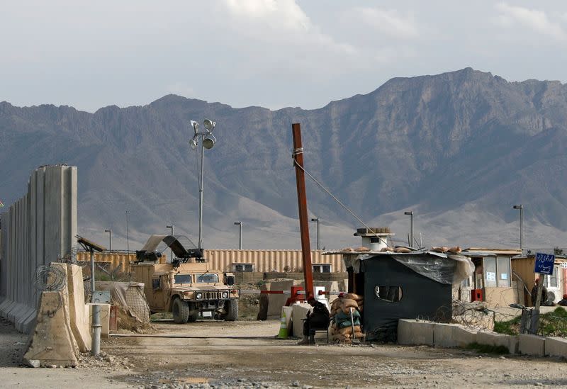 An Afghan National Army (ANA) soldier sits at the gate of Bagram prison, north of Kabul, Afghanistan