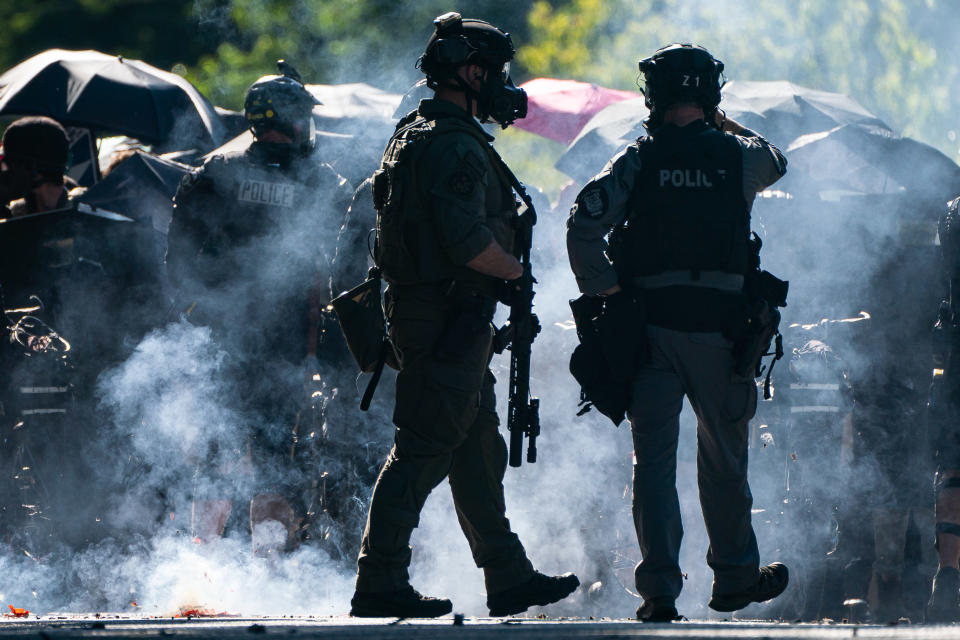 Firecrackers go off near members of a police SWAT team during protests in Seattle. Source: Getty Images