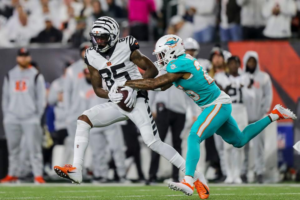 Dolphins cornerback Xavien Howard tries to tackle Bengals receiver Tee Higgins during the second half of Thursday's game in Cincinnati.