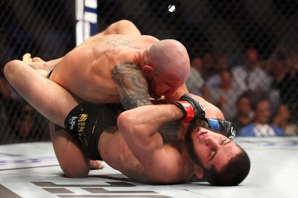 Alexander Volkanovski (pictured left) grapples Islam Makhachev (pictured right).