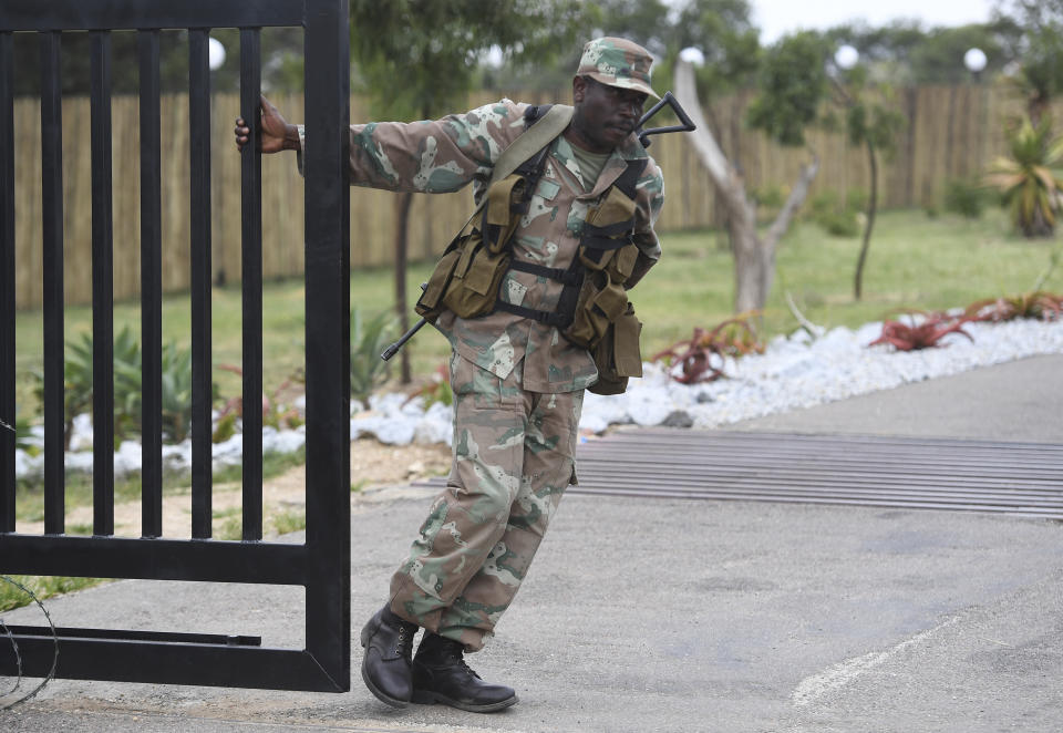 A soldier closes a gate at the entrance, Friday, March 13, 2020, to the venue where repatriated South Africans from Wuhan China will be held in quarantine near Polokwane, South Africa. For most people the new coronavirus causes only mild or moderate symptoms, such as fever and cough. For some, especially older adults and people with existing health problems, it can cause more severe illness, including pneumonia. (AP Photo)