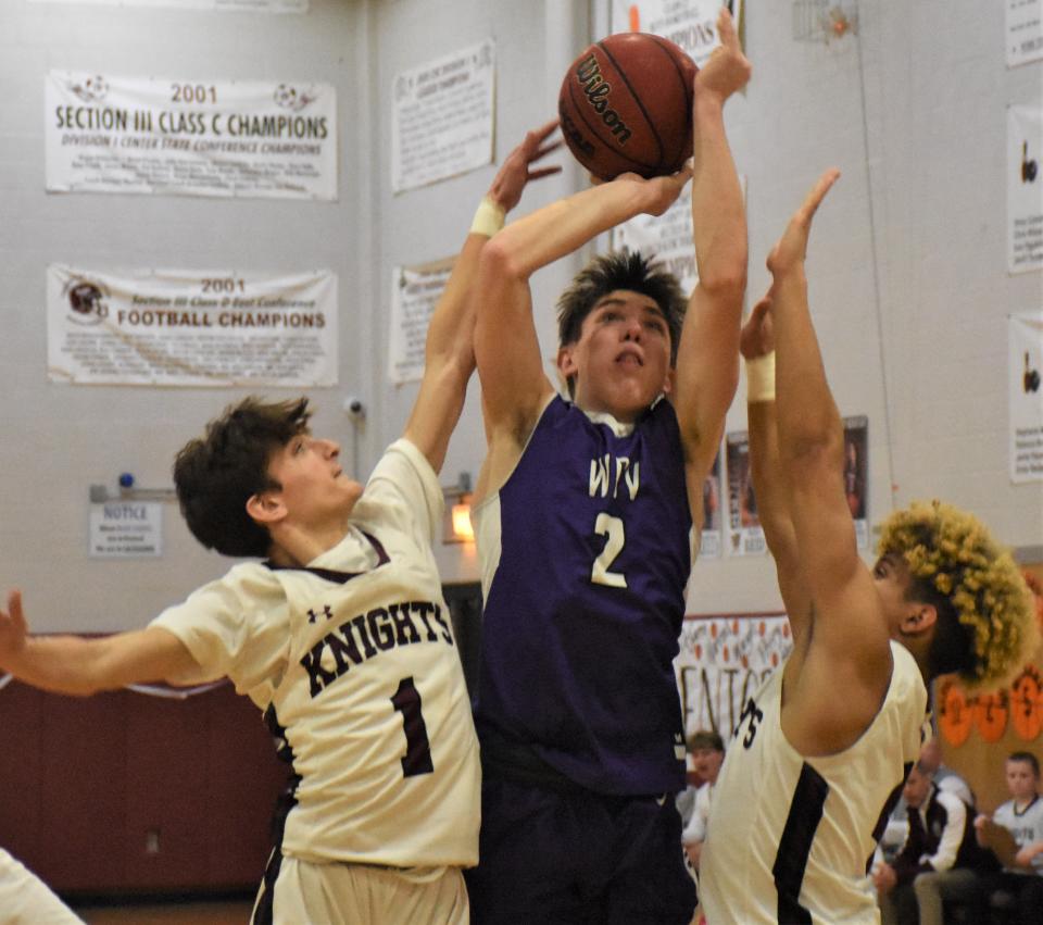 West Canada Valley Nighthawk Jayden Smith shooots between Frankfort-Schuyler Maroon Knights Angelo DeSarro and Lionell Coulthurst (from left) during the second half of Friday's game in Frankfort. Smith scored a game-high 26 points and had 15 of the first 17 for West Canada Valley which trailed by as many as 11 points in a come-from-behind win.