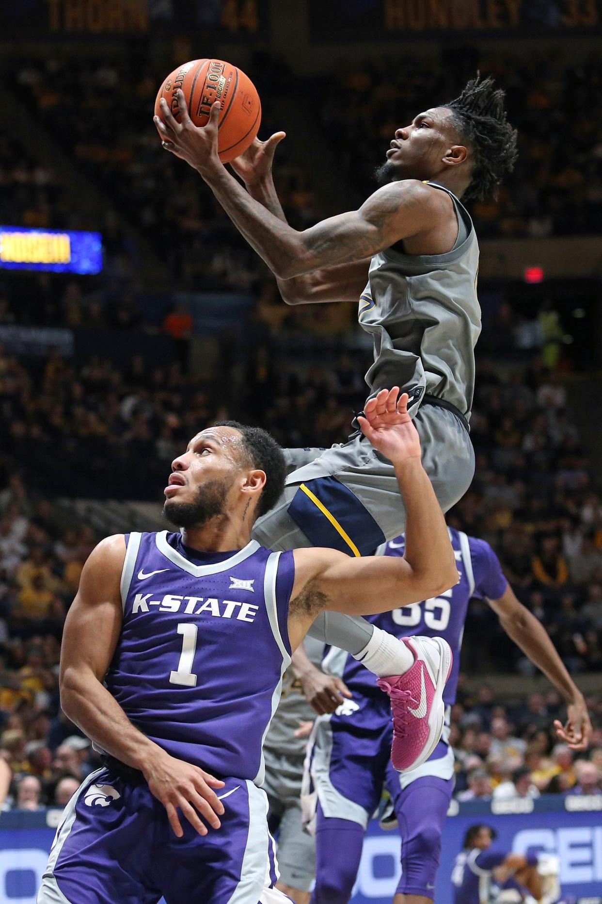 West Virginia guard Kedrian Johnson, right, goes in for a layup over Kansas State's Markquis Nowell (1) during their game Saturday at WVU Coliseum in Morgantown, W.Va.