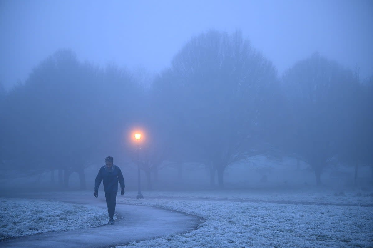 A walker makes their way through fog on a frosty morning at Primrose Hill in north London (AFP via Getty Images)
