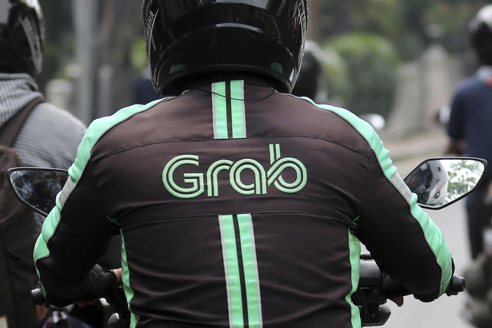 FILE - In this July 24, 2017, file photo, a GrabBike driver rides on his motorbike in Jakarta, Indonesia. Southeast Asia’s largest ride-hailing company, Grab Holdings, said Tuesday, April 13, 2021 that it plans to merge with U.S.-based Altimeter Growth Capital in a deal that would value it at nearly $40 billion in preparation for an initial public offering in the U.S. (AP Photo/Tatan Syuflana, File)