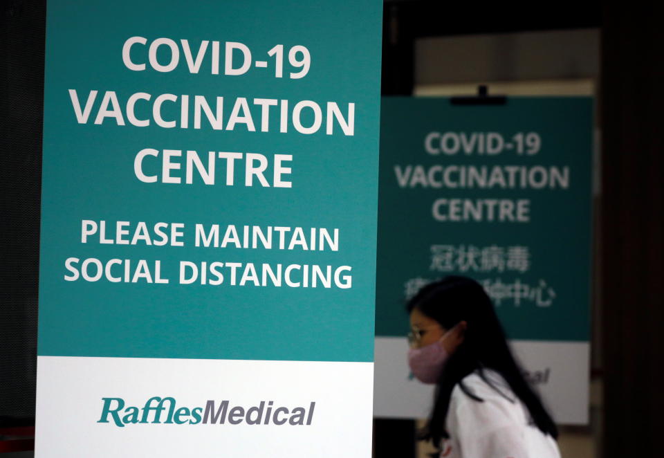 A woman walks into a newly set up coronavirus disease (COVID-19) vaccination center which will be opened to the public the day after, in Singapore January 26, 2021. REUTERS/Edgar Su