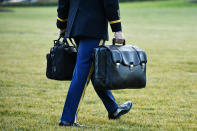 <p>A military aide carries the nuclear "football" with the equipment and nuclear codes to Marine One after the Trumps board. </p>