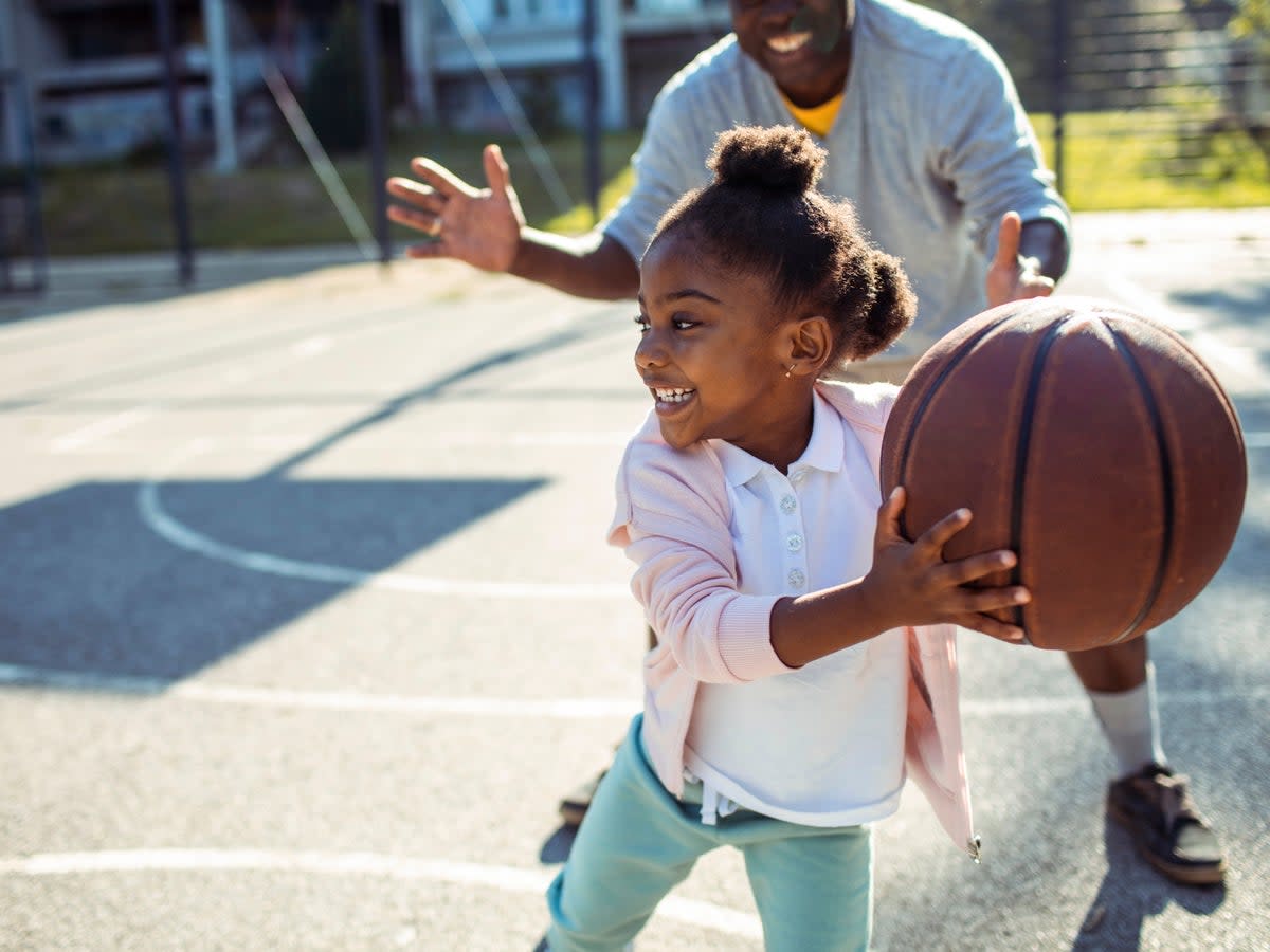 A father plays basketball with his young daughter (iStock)