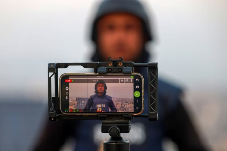 Un journaliste palestinien utilise son téléphone portable pour diffuser des images en direct à Rafah, dans le sud de la bande de Gaza, le 27 décembre 2023, alors que les combats entre Israël et le groupe militant palestinien Hamas se poursuivent (SAID KHATIB)