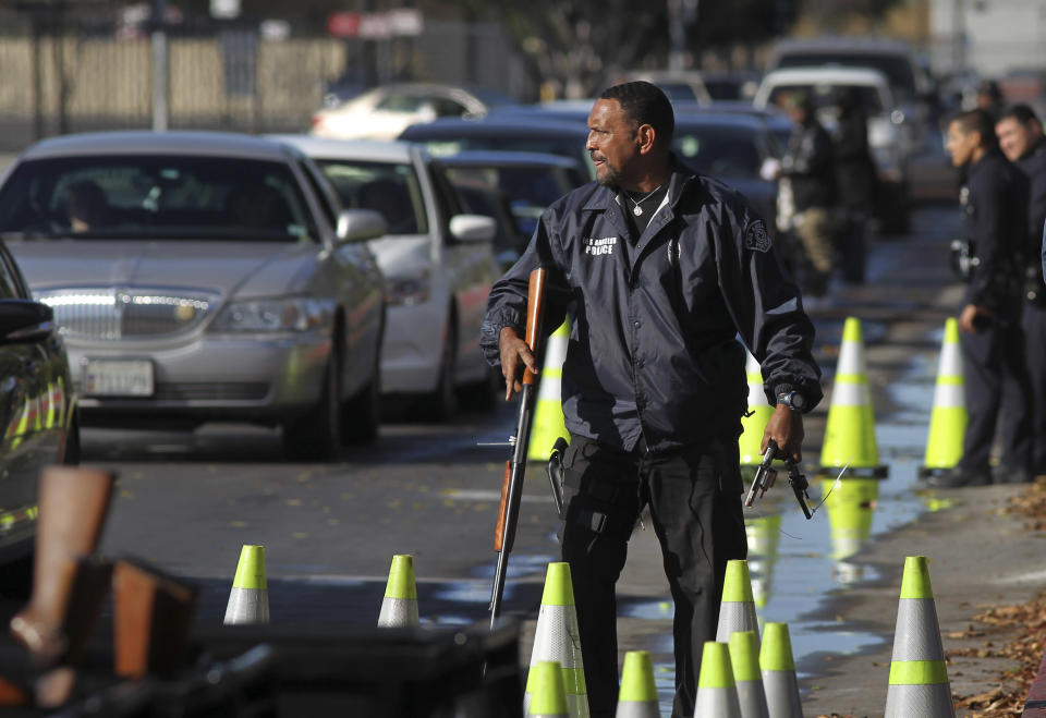 Police officers collect guns from people in their cars at a gun buyback held by the LAPD in Los Angeles