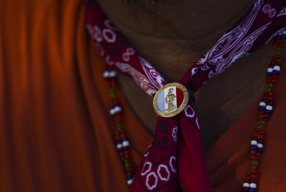 A Yaqui Indigenous person wears a neckerchief tied with the tribe's flag colors, on the outskirts of Vicam, Mexico, Monday, Sept. 26, 2022. The Yaqui Indigenous people of northern Mexico are still mourning the killing of water-defense leader Tomás Rojo in June 2021, whose body was initially identified by a red neckerchief he had been wearing around his neck when he left home. (AP Photo/Fernando Llano)