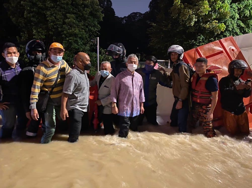 Yang di-Pertuan Agong Al-Sultan Abdullah Ri’ayatuddin Al-Mustafa Billah Shah wades in floodwaters as he checks on the flood situation in Kuala Lumpur. — Picture courtesy of Facebook/Istana Negara