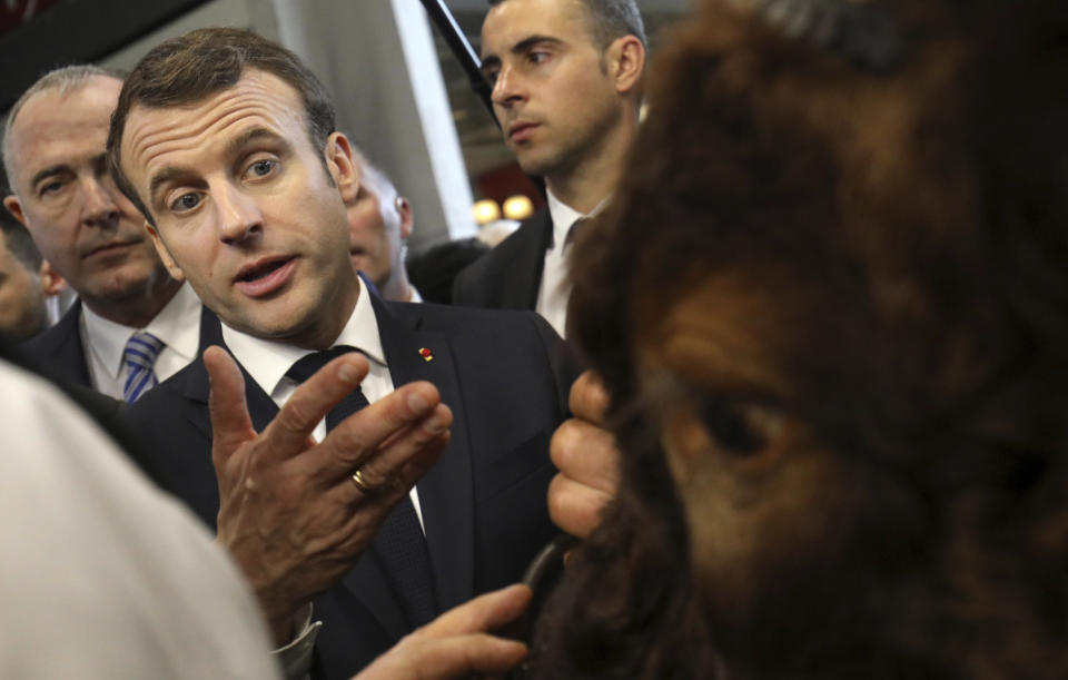 French President Emmanuel Macron gestures while talking to exhibitors as he visits the 56th International Agriculture Fair at the Porte de Versailles exhibition center in Paris, France, Saturday, Feb. 23, 2019. Macron pledged to protect European farming standards and culinary traditions threatened by aggressive foreign trade practices that see food as a "product like any other." (Ludovic Marin/Pool Photo via AP)