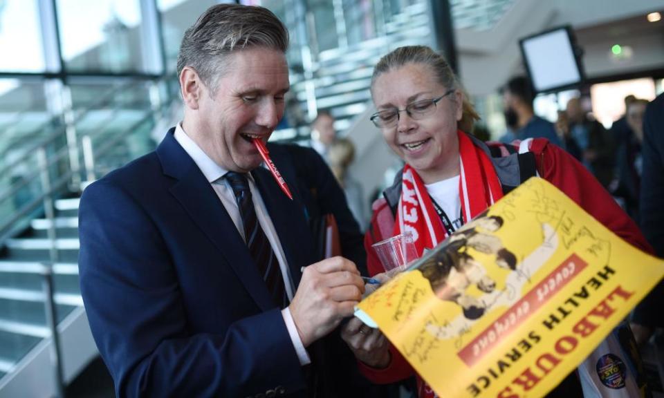 Labour’s Brexit secretary Keir Starmer signs a poster for a delegate 