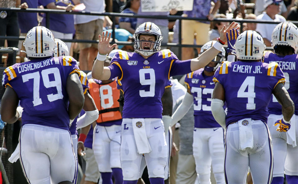 Joe Burrow #9 of the LSU Tigers high-fives teammates after scoring against the Vanderbilt Commodores on Saturday. (Getty)