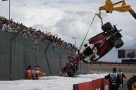 Track workers remove the car of Alfa Romeo driver Guanyu Zhou of China after a crash at the start of the British Formula One Grand Prix at the Silverstone circuit, in Silverstone, England, Sunday, July 3, 2022. (AP Photo/Frank Augstein)