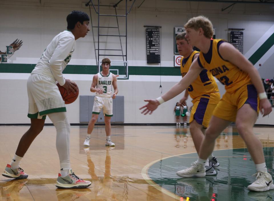 Eldorado High School's Damian Romo, with ball, and Cooper Meador (3) work the Eagles' offense against Ozona defenders Kolton Thompson (foreground) and Aulton Lira during a District 7-2A boys basketball game Tuesday, Jan. 25, 2022, in Eldorado.