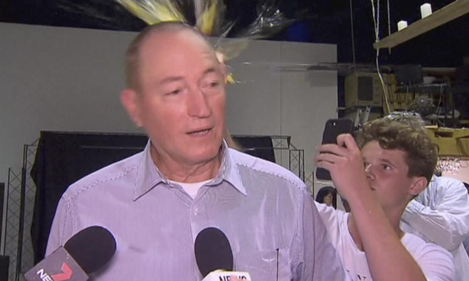 In this image made from video, a teenager breaks an egg on the head of Senator Fraser Anning while he holds a press conference, Saturday, March 16, 2019, in Melbourne, New Zealand. Following the mass shootings on Friday, Anning came under sharp criticism over tweets including one that said: “Does anyone still dispute the link between Muslim immigration and violence?” (AP Photo)