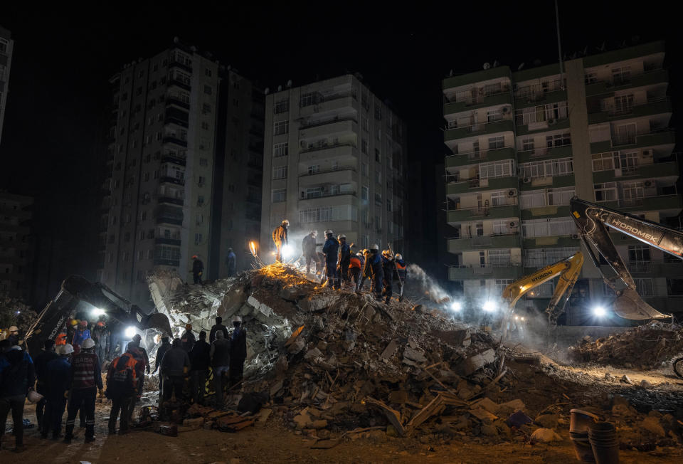 Rescue workers search for bodies and earthquake survivors on a collapsed building in Adana, southeastern Turkey, Friday, Feb. 10, 2023. Some 12,000 buildings in Turkey have either collapsed or sustained serious damage, according to Turkey’s minister of environment and urban planning, Murat Kurum.(AP Photo/Bernat Armangue)