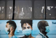 Commuters crowd a bus promoting the use of face masks during the COVID-19 pandemic in Rio de Janeiro, Brazil, Friday, July 23, 2021. (AP Photo/Bruna Prado)