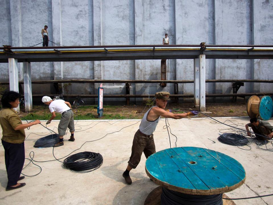 North Korean laborers work together at a fertilizer factory in Hamhung, North Korea's second largest city in South Hamgyong Province, Friday, Aug. 10, 2012.