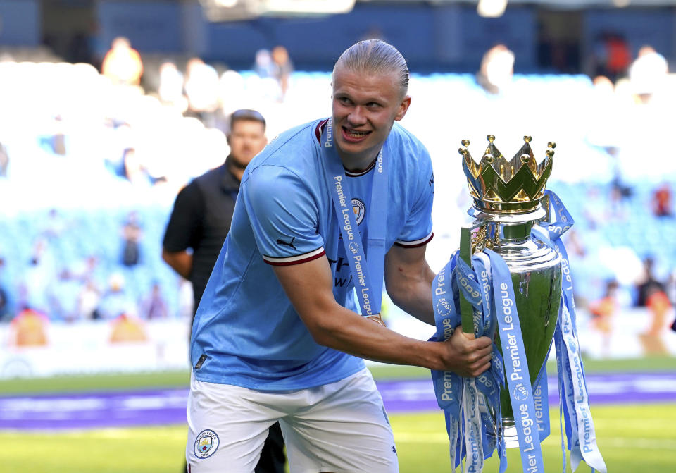Manchester City's Erling Haaland celebrates with the Premier League trophy after their English Premier League title win at the end of the English Premier League soccer match between Manchester City and Chelsea at the Etihad Stadium in Manchester, England, Sunday, May 21, 2023. (Martin Rickett/PA via AP)