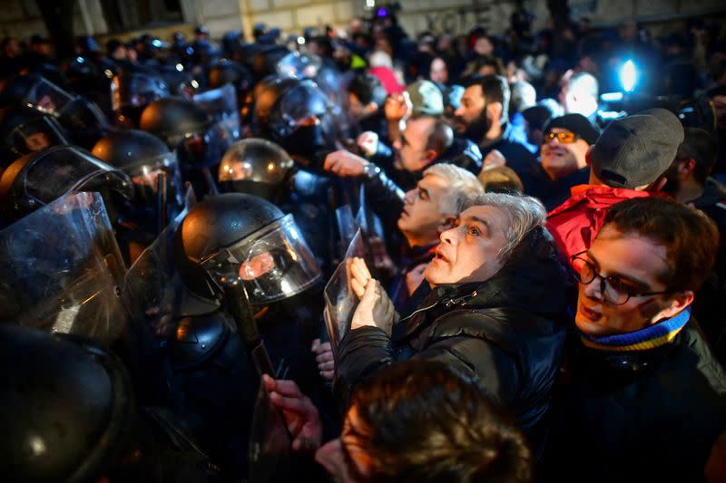 Manifestantes se reúnen frente a agentes de policía, que bloquean el paso durante una concentración contra la ley de "agentes extranjeros" en Tiflis